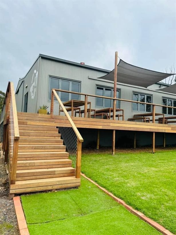 Timber deck and stairs leading down to the lawn beside the cellar door