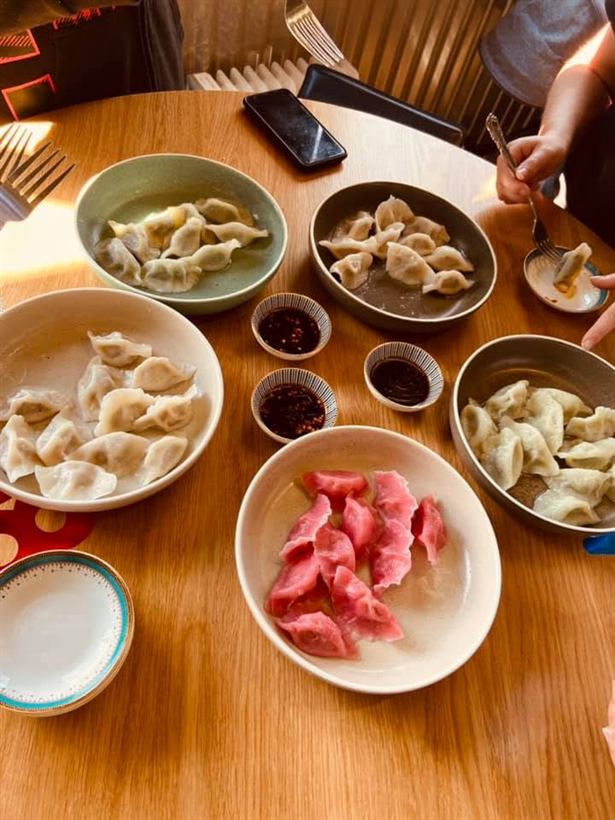 Several bowls of different dumplings on a table